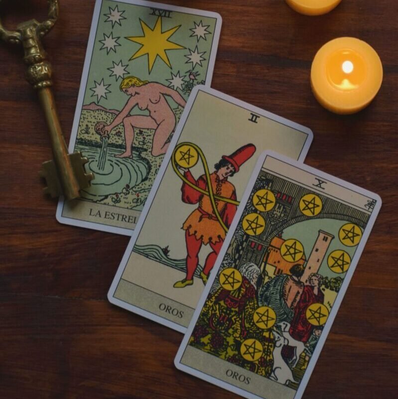 Mystical tarot card reading setup with candles and an antique key.